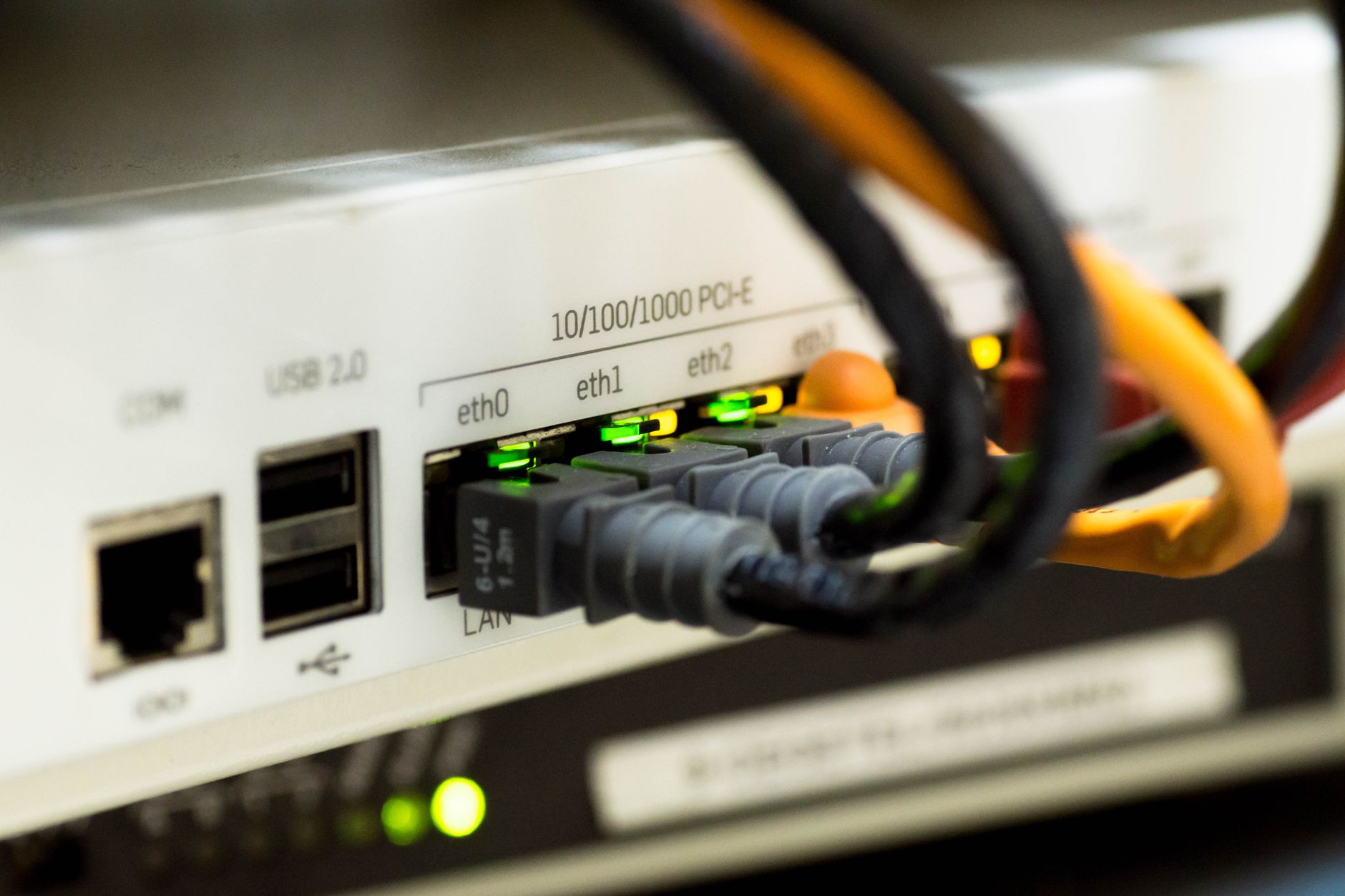 Gros plan détaillé de câbles Ethernet et de connexions réseau sur un routeur, présentant la technologie moderne.
